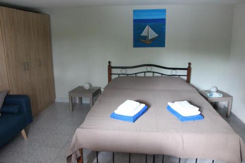 a bedroom with a bed with two towels on it at Vravrona Sea View Country House near Athens in Vravrona