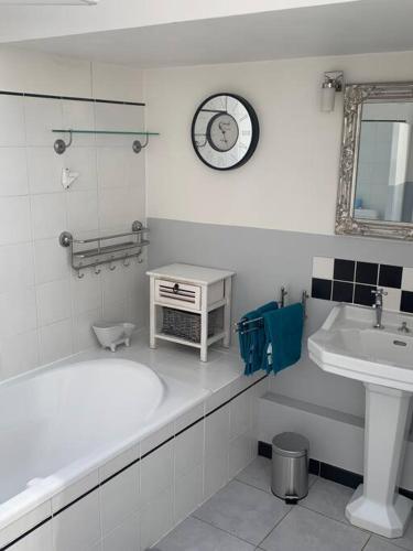 La salle de bains est pourvue d'une baignoire, d'un lavabo et d'un réveil. dans l'établissement Appartement mirepoix, à Mirepoix