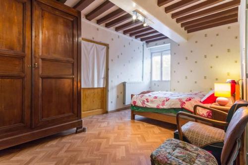 a bedroom with a bed and a wooden cabinet at Gîte d'Haute-Cour in Moraches