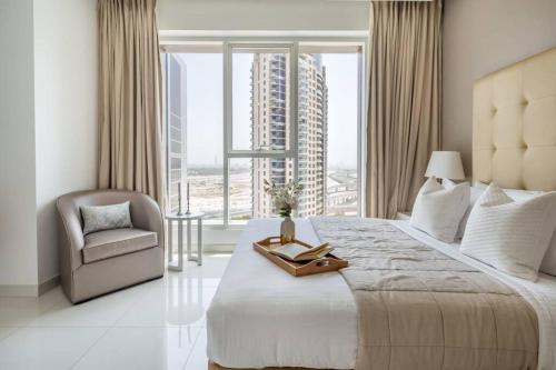 a bedroom with a large bed with a chair and a window at Frank Porter - The Vogue in Dubai