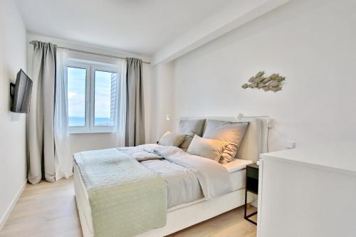 Habitación blanca con cama y ventana en Strandperle Ostsee Suite 1 en Niendorf