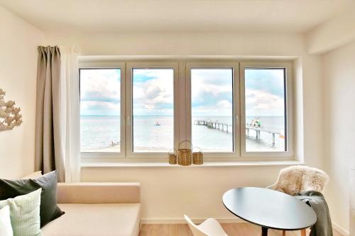 a living room with a window with a view of the beach at Ostsee Suite 4 - Strandperle in Niendorf