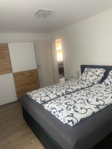 a bedroom with a bed with a black and white comforter at Smart Stay Apartment Feldkirch in Feldkirch