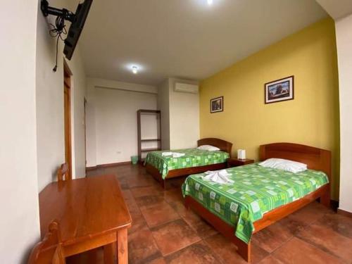 um quarto com 2 camas, uma secretária e uma mesa em Monteverde Tarapoto "Eco-Friendly" em Tarapoto