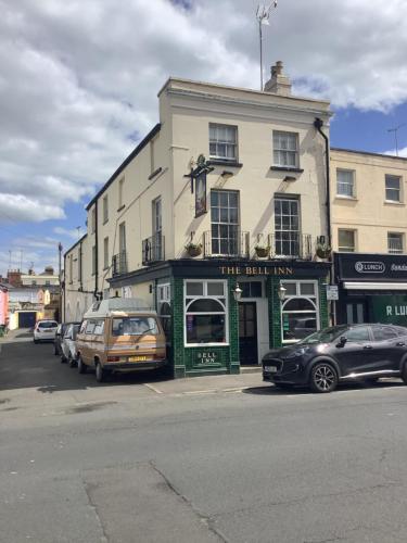 a building on a street with cars parked in front of it at The Bell Inn in Cheltenham