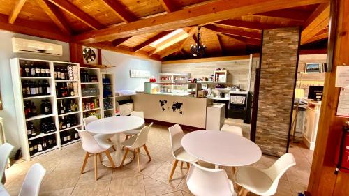 two tables and chairs in a room with a kitchen at Residence Al Lago in Castiglione del Lago