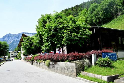 a street in a small town with a building and flowers at Gasthof Oberwirt in Ramsau