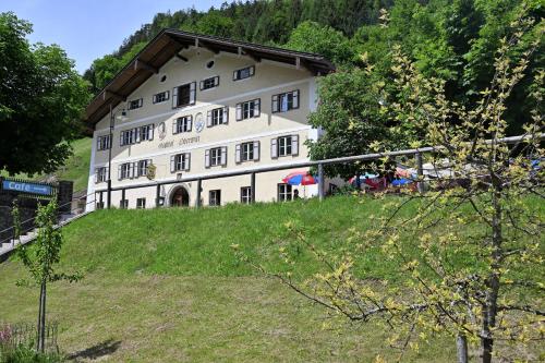 a large white building on a hill with trees at Gasthof Oberwirt in Ramsau
