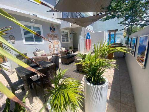 a patio with chairs and plants in a house at Walk to the Beach 2Min, Cozy, Boutique, Pool, Palmeras Del Mar Isabela in Isabela