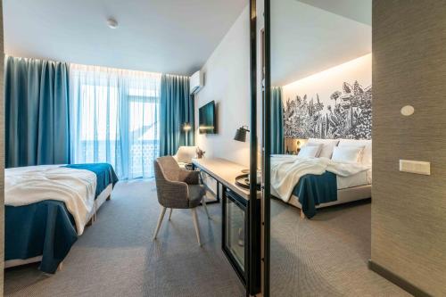um quarto de hotel com duas camas e uma secretária em Hotel HegiQ - Adults Only Hotel em Hegykő