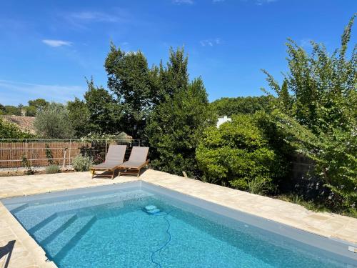 une piscine avec une chaise et une piscine dans l'établissement Studio indépendant - Terrasse et piscine en été, à Restinclières