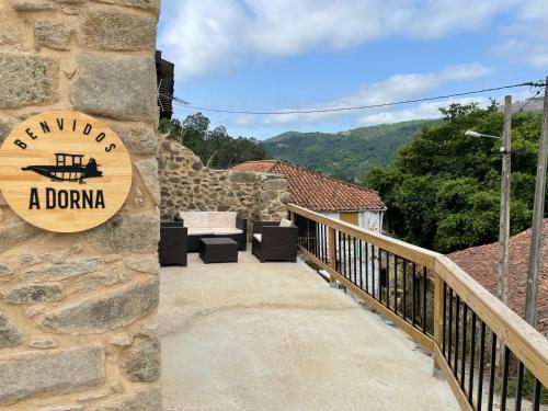 a stone building with a sign on a balcony at Ecolagar O Barqueiro in Pantón