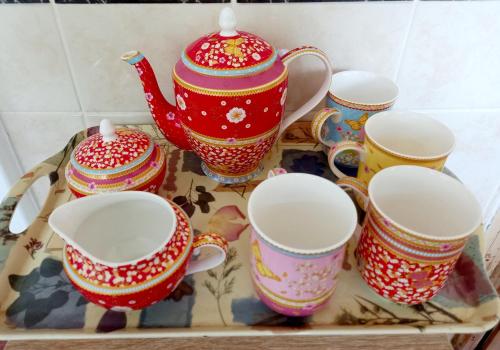 a group of cups and teapots on a table at Luxurious Entire Studio in Axminster suitable for in Axminster