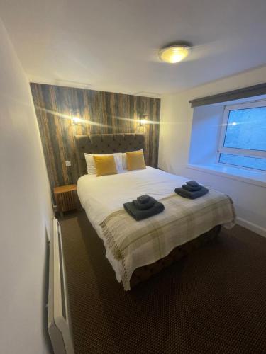 um quarto com uma cama com duas toalhas em Alpine Apartments - 1 em Blairgowrie