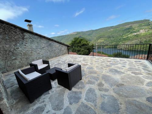 two chairs sitting on a patio with a view at Ecolagar O Barqueiro in Pantón