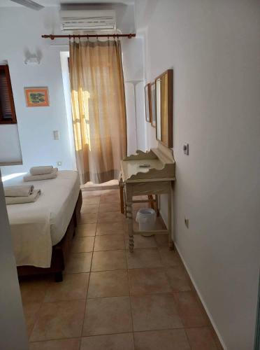 a bedroom with a bed and a desk and a sink at Villa Amalia in Halki