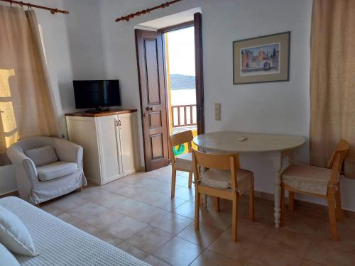 a living room with a table and chairs and a television at Villa Amalia in Halki