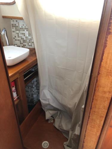 a bathroom with a sink and a shower curtain at La Vedette Hollandaise in Étaples