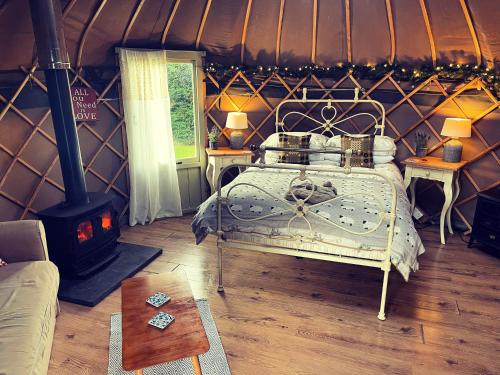a bedroom with a bed in a yurt with a stove at Sunbank Yurt in Llangollen