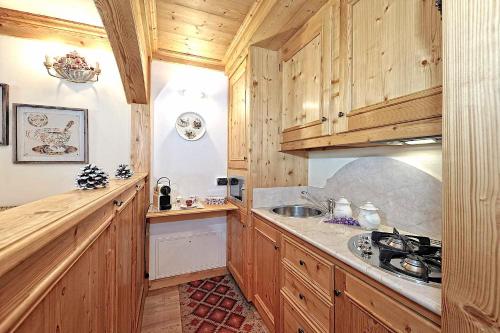 a kitchen with wooden cabinets and a sink at Luxury Apt Dolomites 2 in Pinzolo