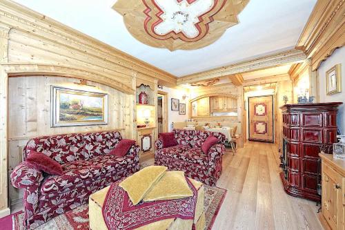 a living room with couches and a chandelier at Luxury Apt Dolomites 2 in Pinzolo