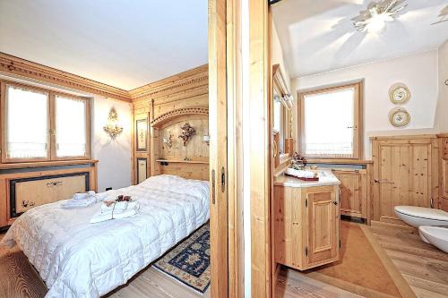 a bedroom with a bed and a sink and a toilet at Luxury Apt Dolomites 2 in Pinzolo