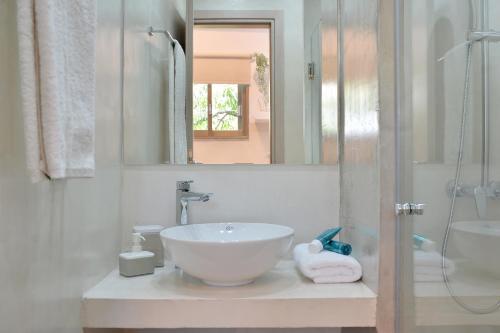 a white bathroom with a sink and a mirror at Niriis Studio 7 Batsi Andros in Batsi