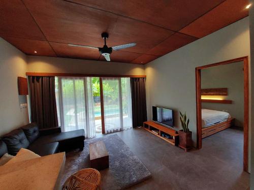 a living room with a ceiling fan and a mirror at Elysian Villa in Kuta Lombok