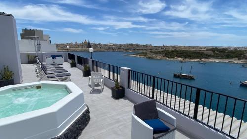 einen Balkon mit Whirlpool und Stühlen auf einem Gebäude in der Unterkunft Sliema Marina Hotel in Sliema