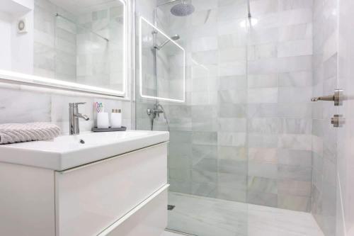a white bathroom with a sink and a shower at Apartamento El Palmer in Almería