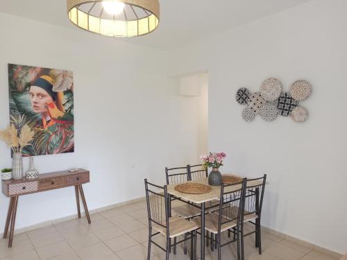 a dining room with a table and chairs and a painting at Sea melody apartments in Stavromenos