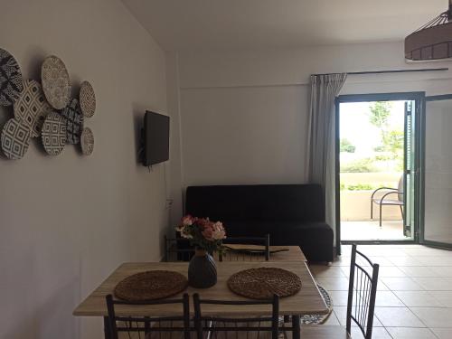 a living room with a table and chairs and a couch at Sea melody apartments in Stavromenos