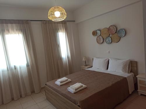 a bedroom with a bed with two towels on it at Sea melody apartments in Stavromenos