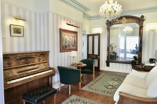 a living room with a piano and a mirror at The Buckley Arms in Dinas Mawddwy