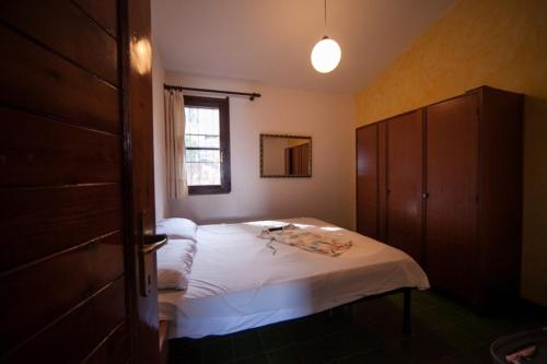 Schlafzimmer mit einem Bett und einem Fenster in der Unterkunft Appartamento Sole e Mare in Santa Margherita di Pula