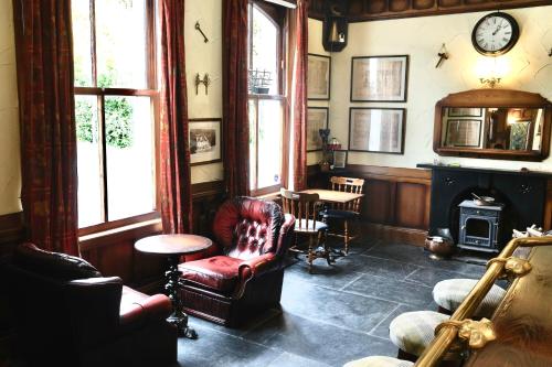 a living room with a chair and a clock on the wall at The Buckley Arms in Dinas Mawddwy