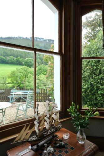 a table with a pirate ship in front of a window at The Buckley Arms in Dinas Mawddwy