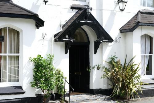 an entrance to a white house with a black door at The Buckley Arms in Dinas Mawddwy