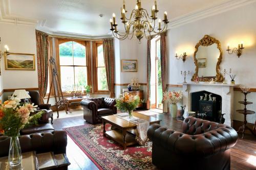 a living room with leather furniture and a fireplace at The Buckley Arms in Dinas Mawddwy