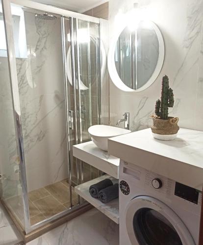 a bathroom with a sink and a washing machine at Sea melody apartments in Stavromenos