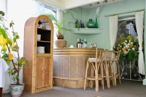 a room with a bar with wicker stools at The Buckley Arms in Dinas Mawddwy