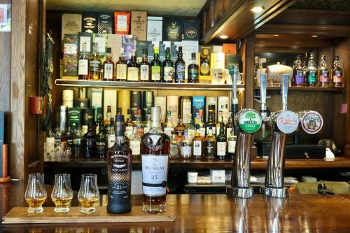 a bar with many bottles of alcohol and wine glasses at The Buckley Arms in Dinas Mawddwy