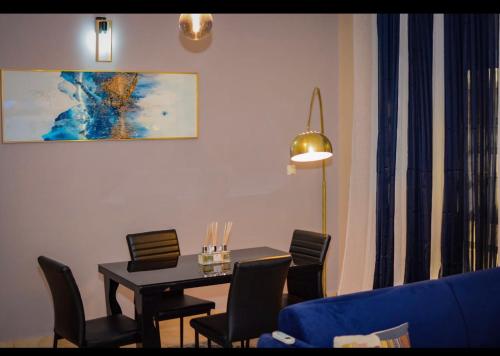 - une salle à manger avec une table et des chaises dans l'établissement Appartement cosy goldy bonapriso, à Douala