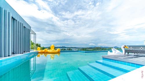 een zwembad met opblaasbare rubberen eenden in het water bij The Aristo-2-803 in Phuket