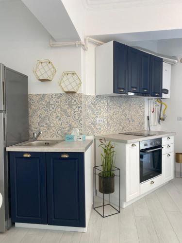 a kitchen with blue cabinets and a sink and a stove at Luxury Studio Solid Butoaie in Mamaia