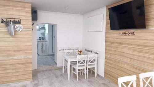 Trhové Sviny的住宿－Penzion HARMONIE，一间设有桌子的用餐室和墙上的电视
