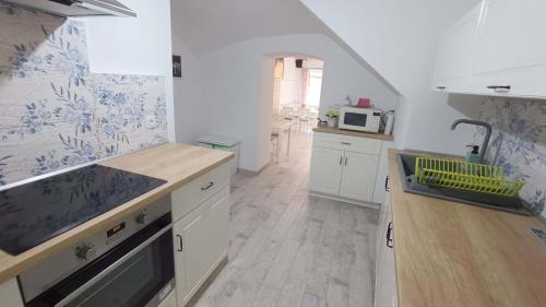 a kitchen with white cabinets and a sink and a microwave at Penzion HARMONIE in Trhové Sviny