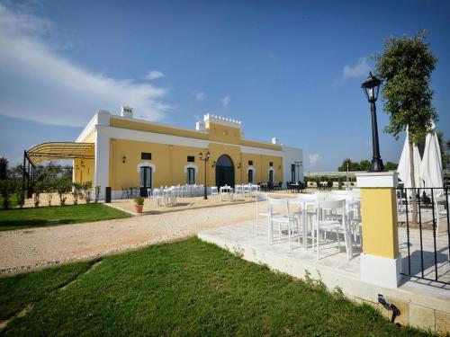 a building with tables and chairs in front of it at Tenuta Orsanese in Ginosa Marina