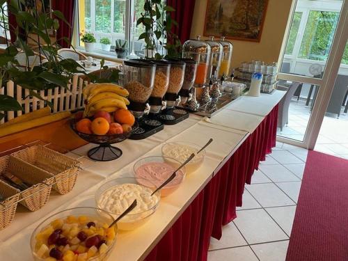 a long table with bowls of fruit on it at Waldhotel Harz Ilsenburg in Ilsenburg
