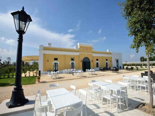a group of tables and chairs in front of a building at Tenuta Orsanese in Ginosa Marina